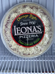 A packaged, frozen Leona's Chicago Style Thin Crust Pizza in a clear plastic container, with the branding and toppings visible.